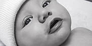 Stetson is registered to the contest to win money with this photo: baby, infant, face, hat, beanie, skin, eyes, mouth, cheeks, lying_down, portrait, black_and_white, closeup, cute, newborn, expression, soft, young_child, headwear, person