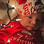 baby, infant, christmas, holiday, festive, red_clothing, santa_hat, lights, indoors, cute, sleepwear, celebration, newborn, child, face, portrait, holiday_season, warm_lighting, cozy, christmas_lights