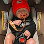 baby, infant, car_seat, pacifier, orange_hat, clothing, straps, safety, child, cute, newborn, seat_belt, car_accessory, baby_gear, black_outfit, headwear, indoor, human, skin, face