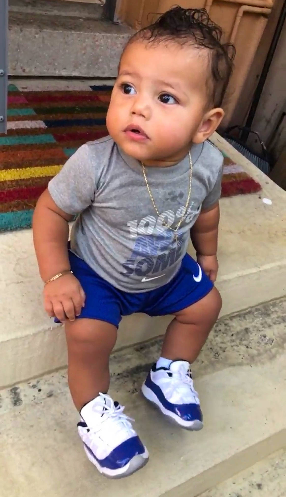 Deandre is registered to the contest to win money with this photo: baby, baby_toddler_clothing, child, eye, face, flooring, hair, hairstyle, happy, head, knee, nose, person, shoe, shorts, skin, sleeve, sneakers, t_shirt, thigh