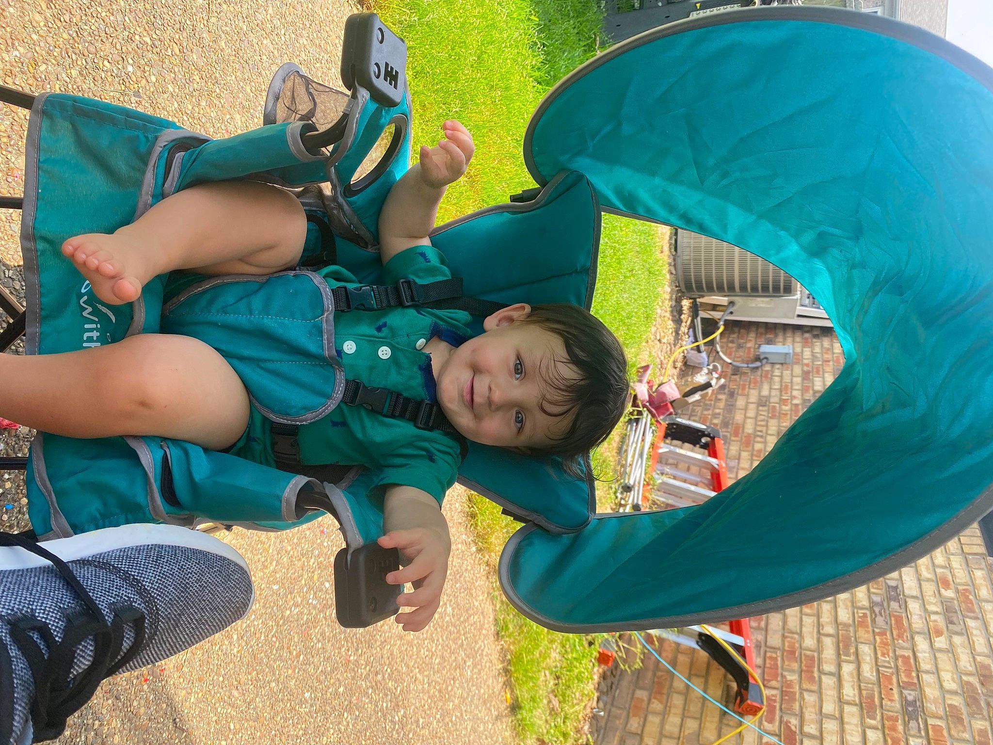 Callum is registered to the contest to win money with this photo: azure, baby, blue, child, clothing, electric_blue, fun, grass, green, happy, joy, leaf, leg, leisure, outdoor_play_equipment, person, plant, recreation, sitting, t_shirt