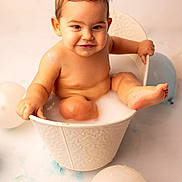 Lyzao participe au concours pour gagner de l'argent avec cette photo : baby, balloons, bath_time, bathtub, bathwater, bucket, chubby_cheeks, cute, hands, infant, milk_bath, playful, portrait, sitting, smile, studio_background, toddler, toes, wet_skin, white_background