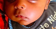 Khrome is registered to the contest to win money with this photo: baby, sleeping, child, infant, portrait, close_up, face, eyes_closed, peaceful, blanket, clothing, indoor, cozy, resting, cheeks, head, hand, textile, colorful, photograph
