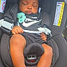 baby, infant, sleeping, car_seat, pacifier, nike, black_clothing, sandals, child, portrait, vehicle, safety_harness, seated, closed_eyes, curly_hair, hands, legs, indoor, photography, calm