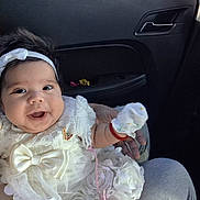 Yusnielis is registered to the contest to win money with this photo: baby, bow, car_interior, child, closeup, cute, fabric, floral, hand, happy, headband, holding, infant, lace, mitten, person, portrait, seated, smiling, white_dress