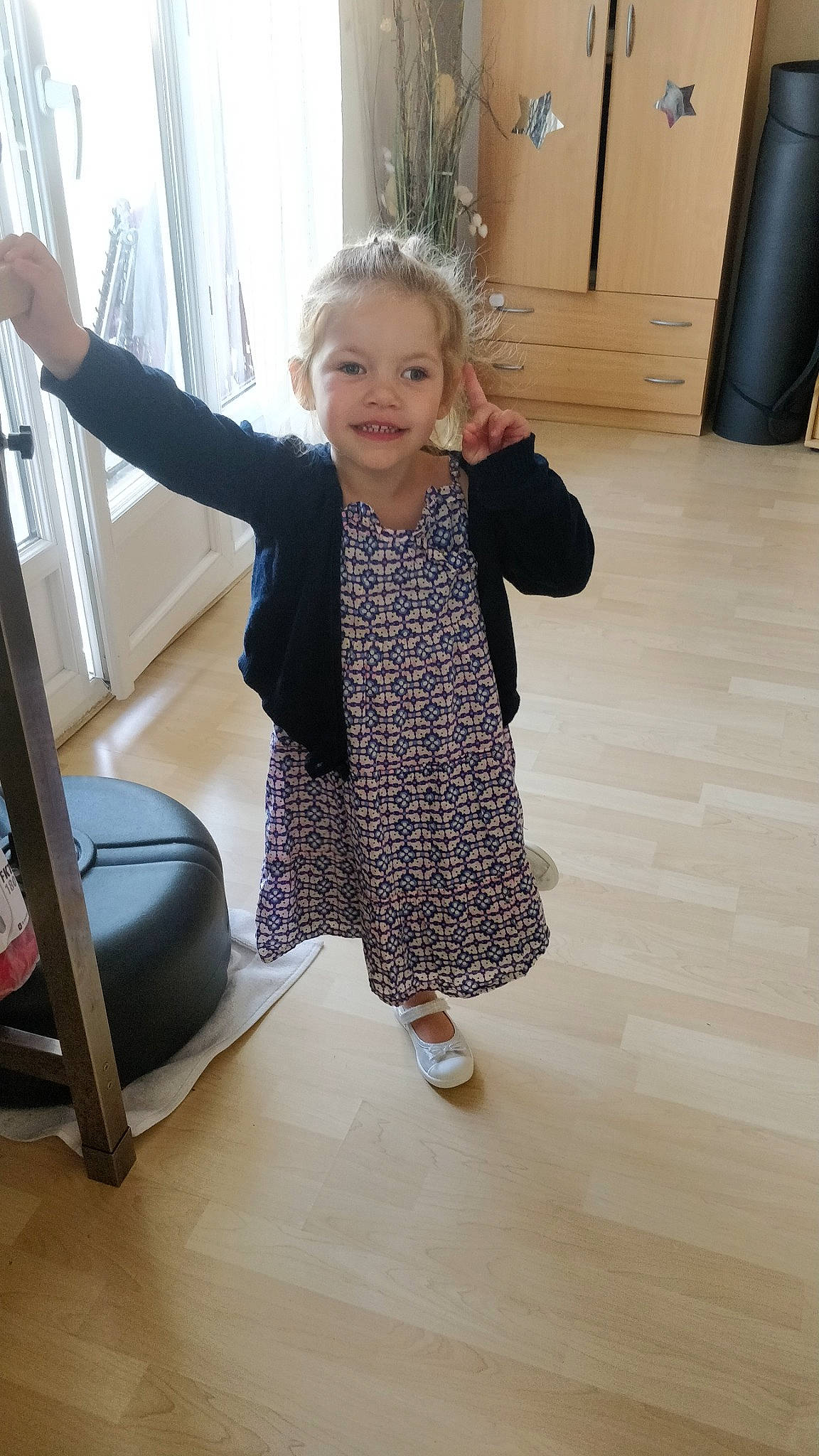 Alix a rejoint le concours — aidez-le/la à gagner de superbes lots ! baby_toddler_clothing, cabinetry, dress, finger, floor, flooring, gesture, hairstyle, hardwood, joint, joy, knee, leg, person, sleeve, smile, sock, standing, thumb, toddler