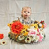 child, toddler, baby, portrait, face, blonde_hair, blue_eyes, basket, flowers, bouquet, wicker, floral, colorful, studio, backdrop, sitting, infant, clothing, indoors, photography