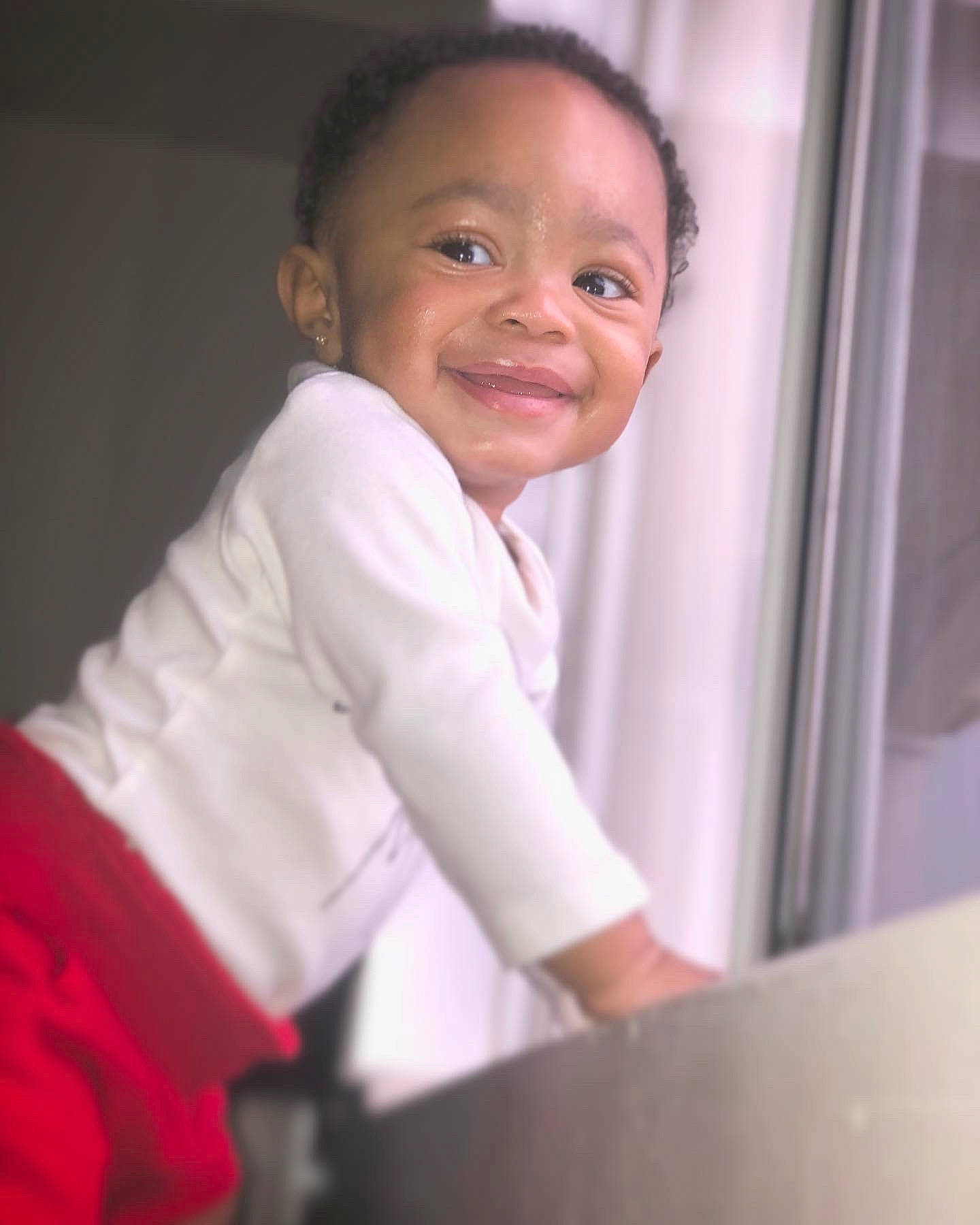 Hezekiah is registered to the contest to win money with this photo: abdomen, baby, baby_products, cheek, child, elbow, flash_photography, fun, gesture, happy, human_body, joy, nose, person, room, sitting, sleeve, smile, standing, t_shirt