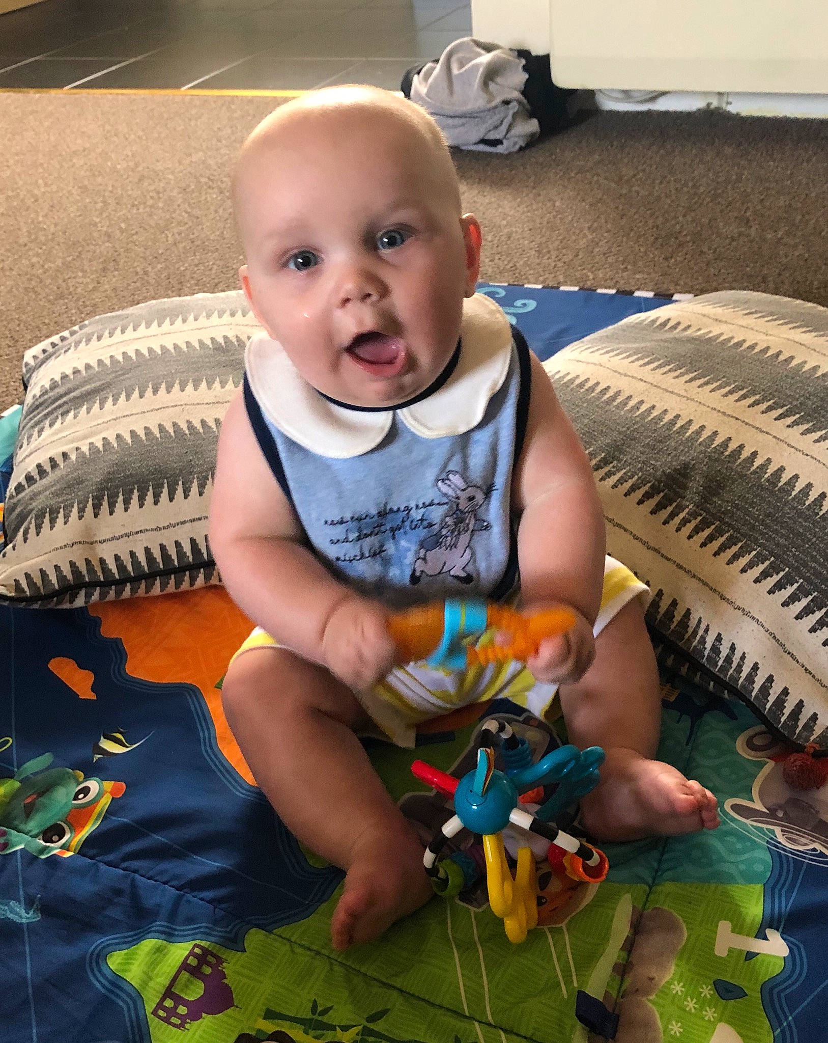 Noah is registered to the contest to win money with this photo: baby, cheek, child, head, leg, mouth, person, play, sitting, skin, smile, surprise, toddler, toy