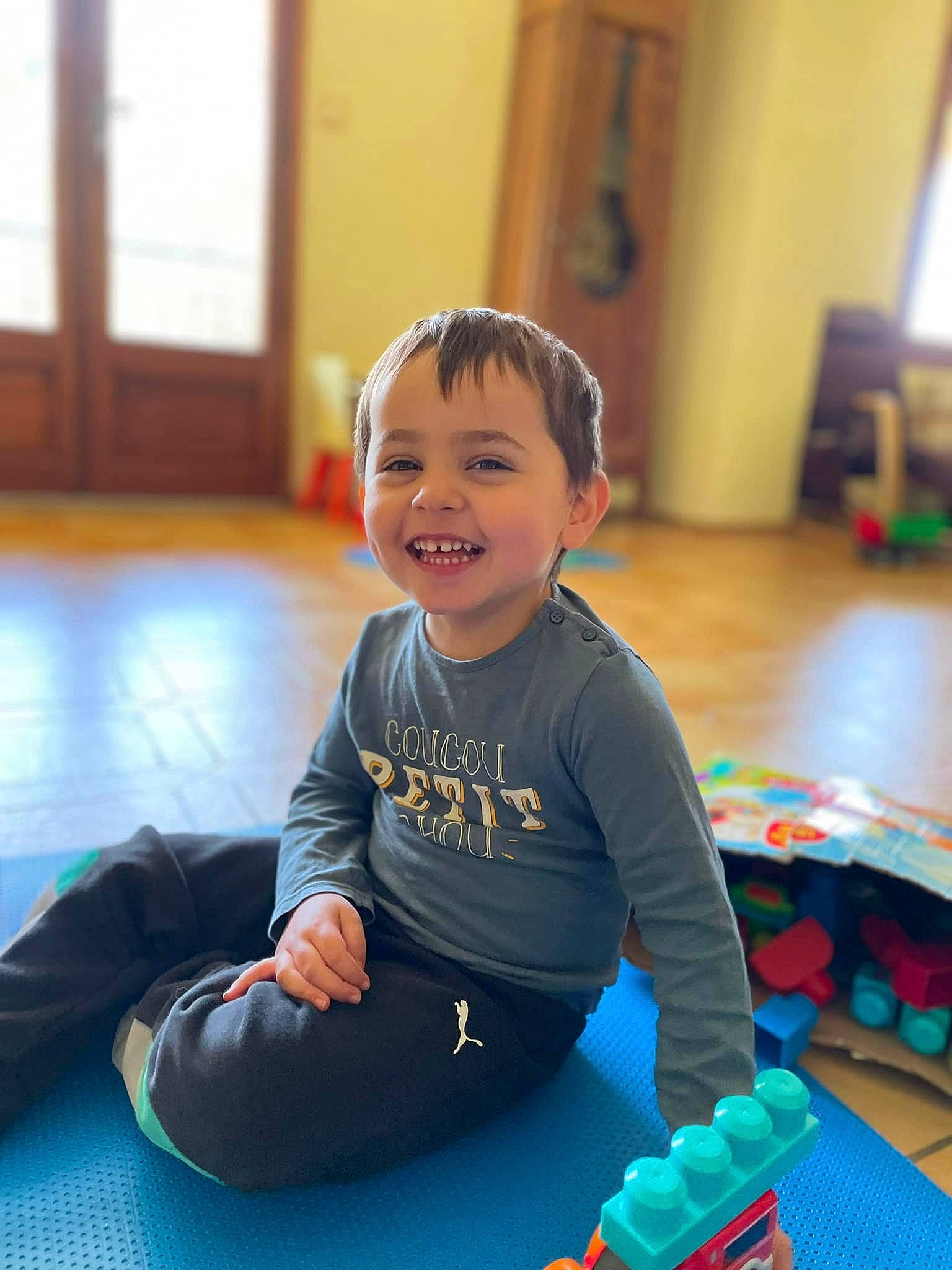 Titi a rejoint le concours — aidez-le/la à gagner de superbes lots ! baby, baby_playing_with_toys, baby_toddler_clothing, child, electric_blue, floor, flooring, fun, happy, hardwood, joy, knee, leisure, person, play, recreation, room, sitting, sleeve, smile