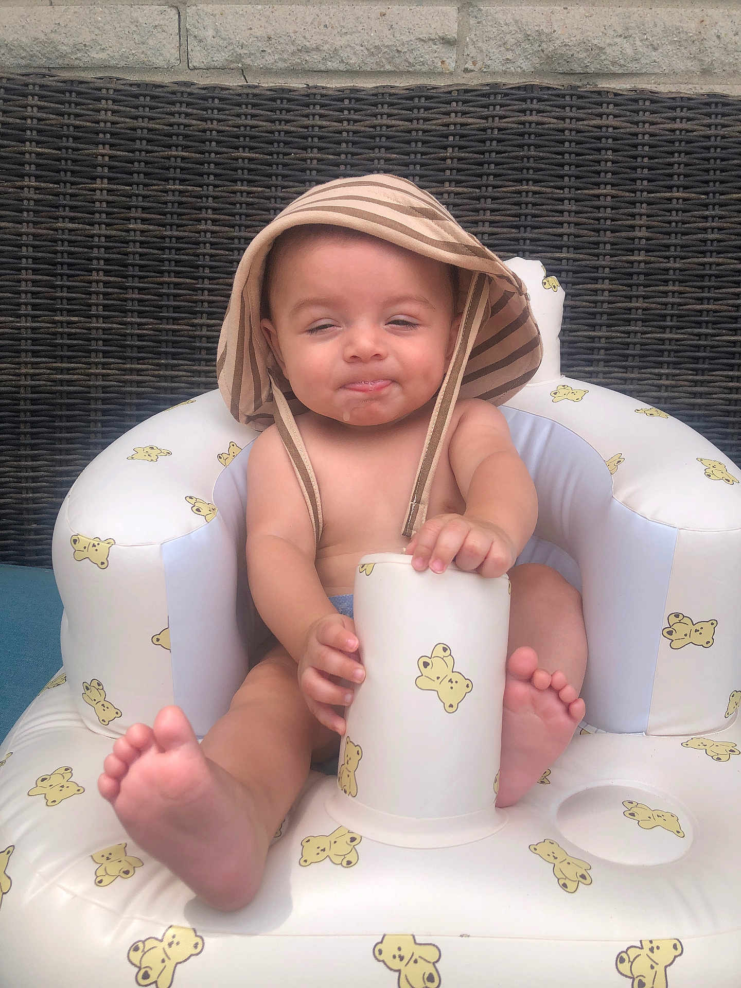 Giovanni joined the competition — help win amazing prizes! baby, infant, hat, striped_hat, inflatable_chair, teddy_bear_pattern, cup, drool, barefoot, cute, child, summer, outdoor, wicker_background, seat, playful, fun, relaxed, young_child, adorable
