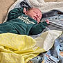 Giovanni joined the competition — help win amazing prizes! baby, newborn, smiling, blanket, couch, clothing, infant, face, sleeping, cozy, soft, text, green, yellow, striped, pattern, fabric, relaxing, indoors, comfort