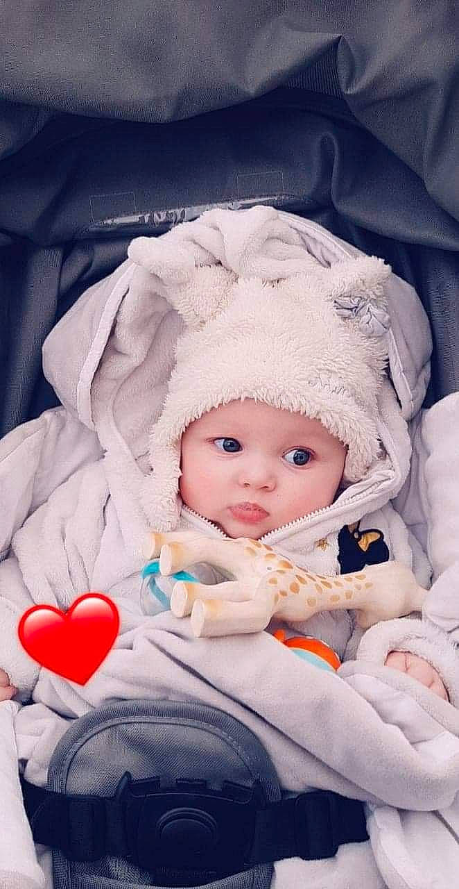 Tressia a rejoint le concours — aidez-le/la à gagner de superbes lots ! baby, baby_products, baby_safety, baby_sleeping, baby_toddler_clothing, beanie, cheek, child, comfort, eye, fun, head, headwear, iris, knit_cap, linens, mouth, person, sitting, skin