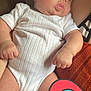 baby, infant, white_onesie, chubby, curious, indoor, couch, hand, furniture, skin, head, face, person, child, young, cute, plush, soft, comfort, heart_sticker