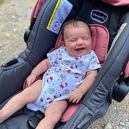 Zariah is registered to the contest to win money with this photo: baby, car_seat, infant, smiling, hello_kitty, onesie, clothing, outdoor, happy, child, seat, pink, black, person, cute, infancy, baby_girl, legs, face, small_child