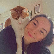 Sherco a rejoint le concours — aidez-le/la à gagner de superbes lots ! woman, cat, indoor, selfie, smile, shoulder, orange_cat, white_cat, long_hair, black_clothing, framed_picture, wall, window, natural_light, pet, companion, face, portrait, friendly, cozy