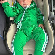 Isaac participe au concours pour gagner de l'argent avec cette photo : baby, child, car_seat, green_tracksuit, adidas, nike_shoes, sneakers, pacifier, indoor, seat, child_clothing, footwear, person, infant, young_child, casual_wear, cute, portrait, serious_expression, car_interior