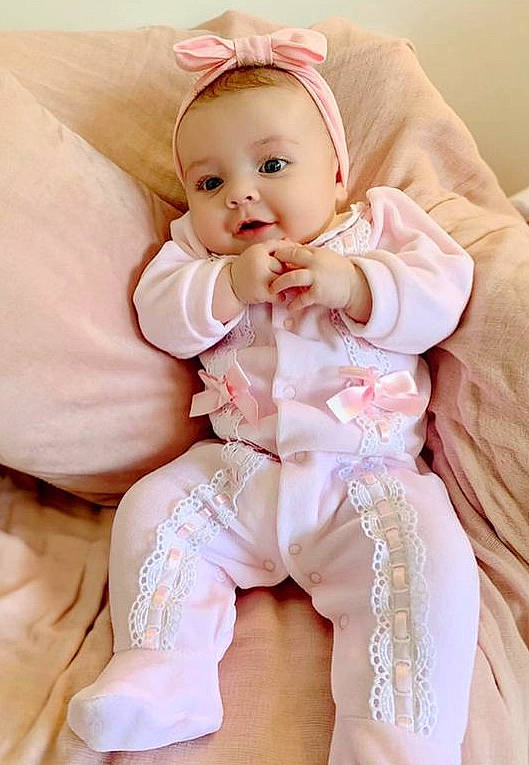 Darcie is registered to the contest to win money with this photo: abdomen, arm, baby, baby_toddler_clothing, cheek, child, comfort, face, finger, gesture, happy, human_body, human_leg, neck, pattern, person, pink, skin, sleeve, thigh