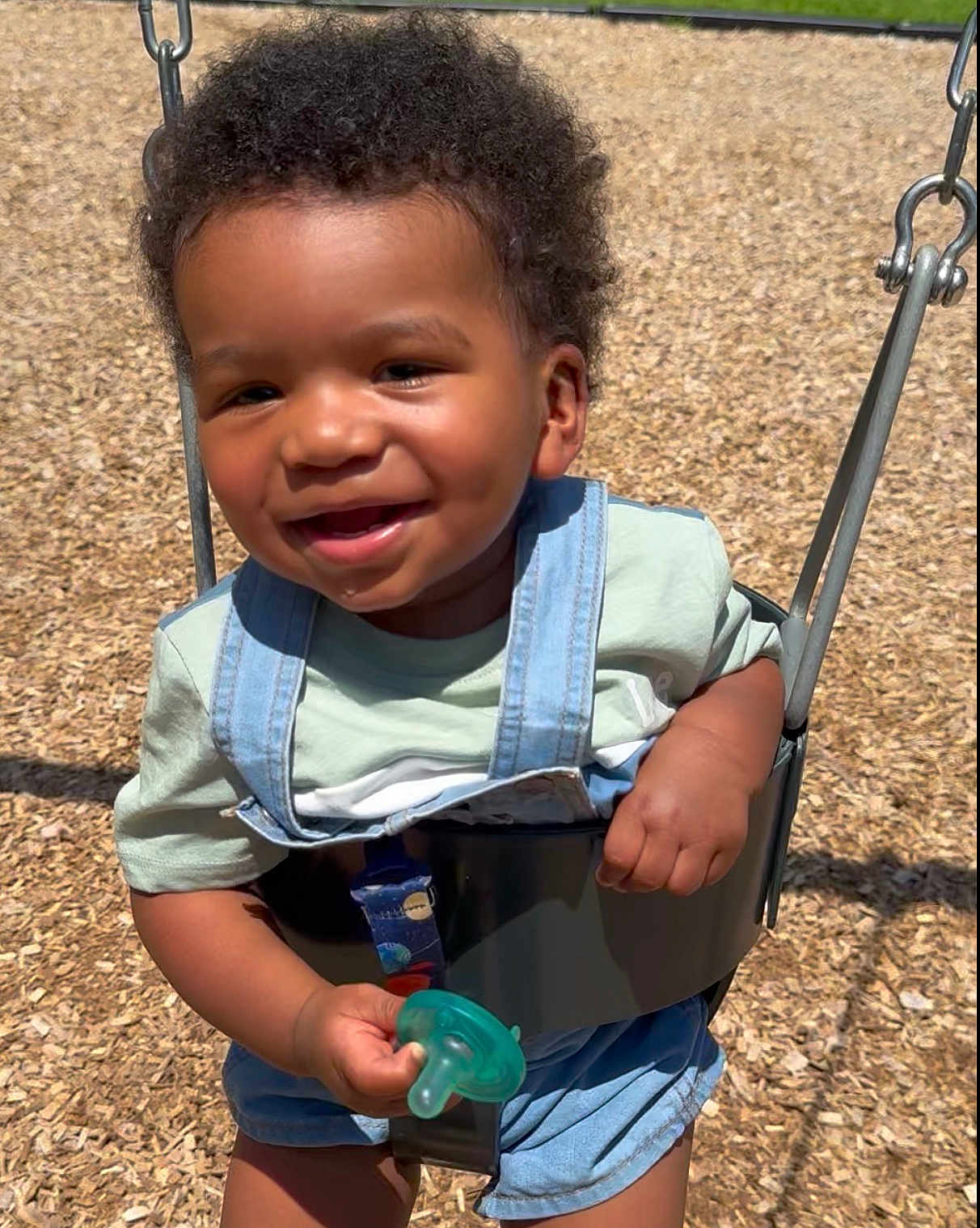 Marcal joined the competition — help win amazing prizes! toddler, child, swing, playground, pacifier, smiling, sunlight, outdoor, curly_hair, denim_overalls, green_pacifier, wood_chips, happy, baby, shorts, clothing, play, fun, person, summer