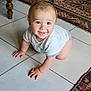 Hugo participe au concours pour gagner de l'argent avec cette photo : baby, crawling, floor, tiled_floor, rug, patterned_rug, wooden_furniture, smiling, happy, indoor, child, cute, person, short_hair, white_shirt, gray_shorts, hands, eyes, face, home