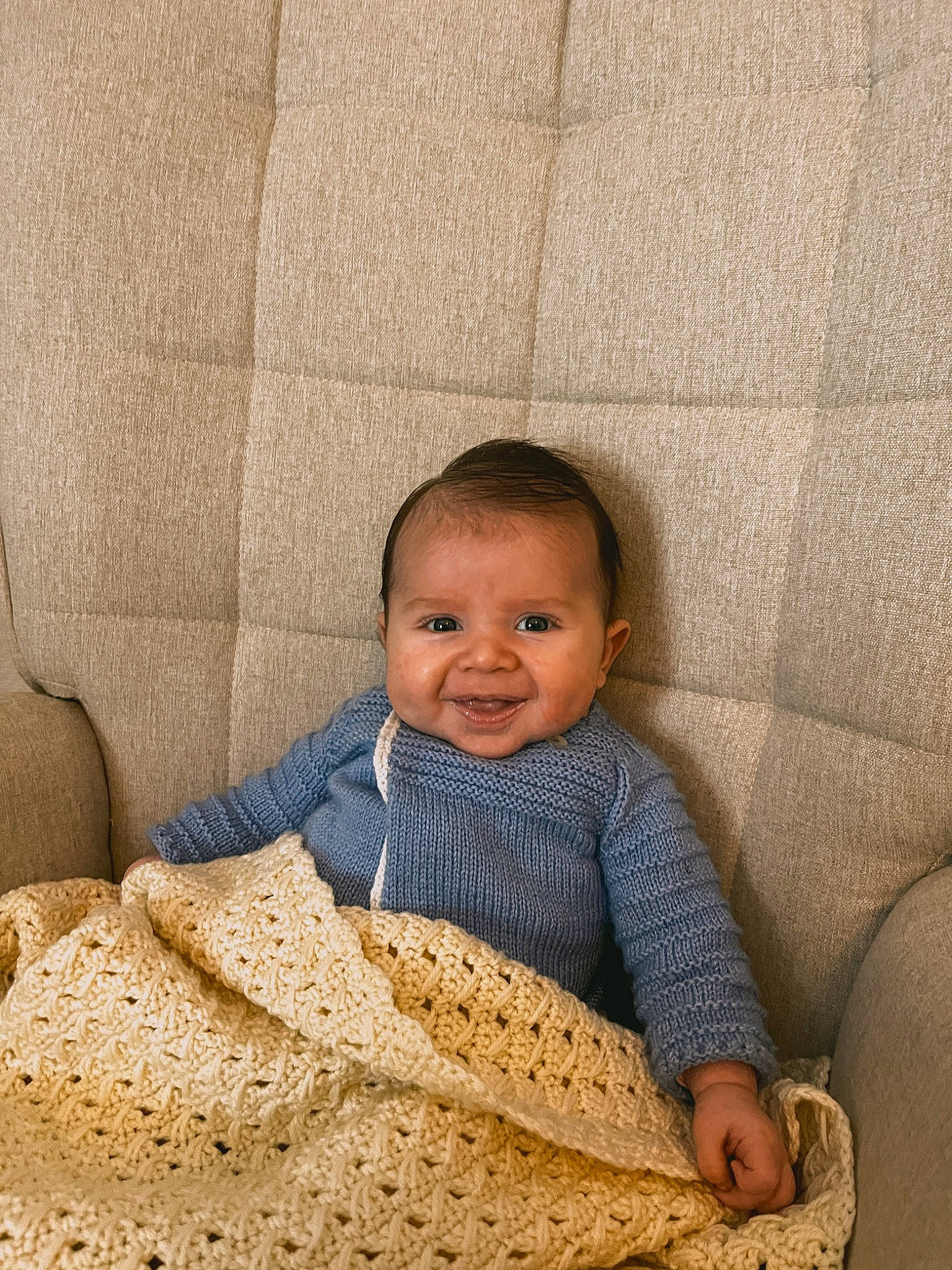 Izaac participe au concours pour gagner de l'argent avec cette photo : baby, baby_toddler_clothing, carpet, child, comfort, face, flooring, happy, joy, linens, pattern, person, room, sitting, skin, sleeve, smile, toddler, wood, wool