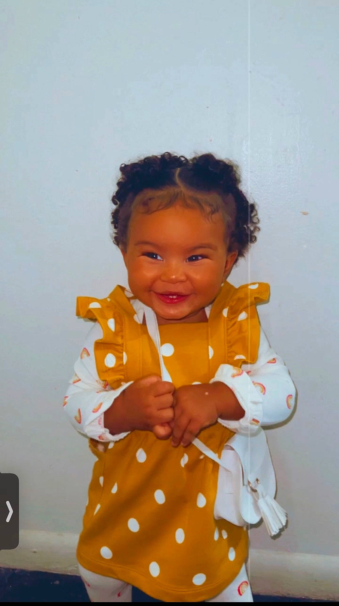 Kaelynn joined the competition — help win amazing prizes! arm, baby_toddler_clothing, cheek, child, fun, gesture, happy, human_body, joy, one_piece_garment, pattern, peach, person, room, sitting, sleeve, smile, standing, thumb, toddler