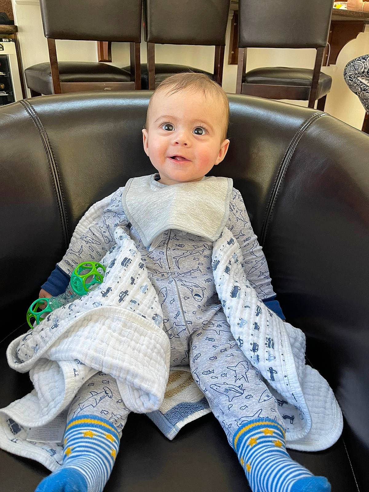 Sam is registered to the contest to win money with this photo: auto_part, automotive_design, baby, baby_toddler_clothing, car_seat, car_seat_cover, chair, child, comfort, couch, furniture, human_leg, lap, living_room, outerwear, person, product, sitting, smile, thigh