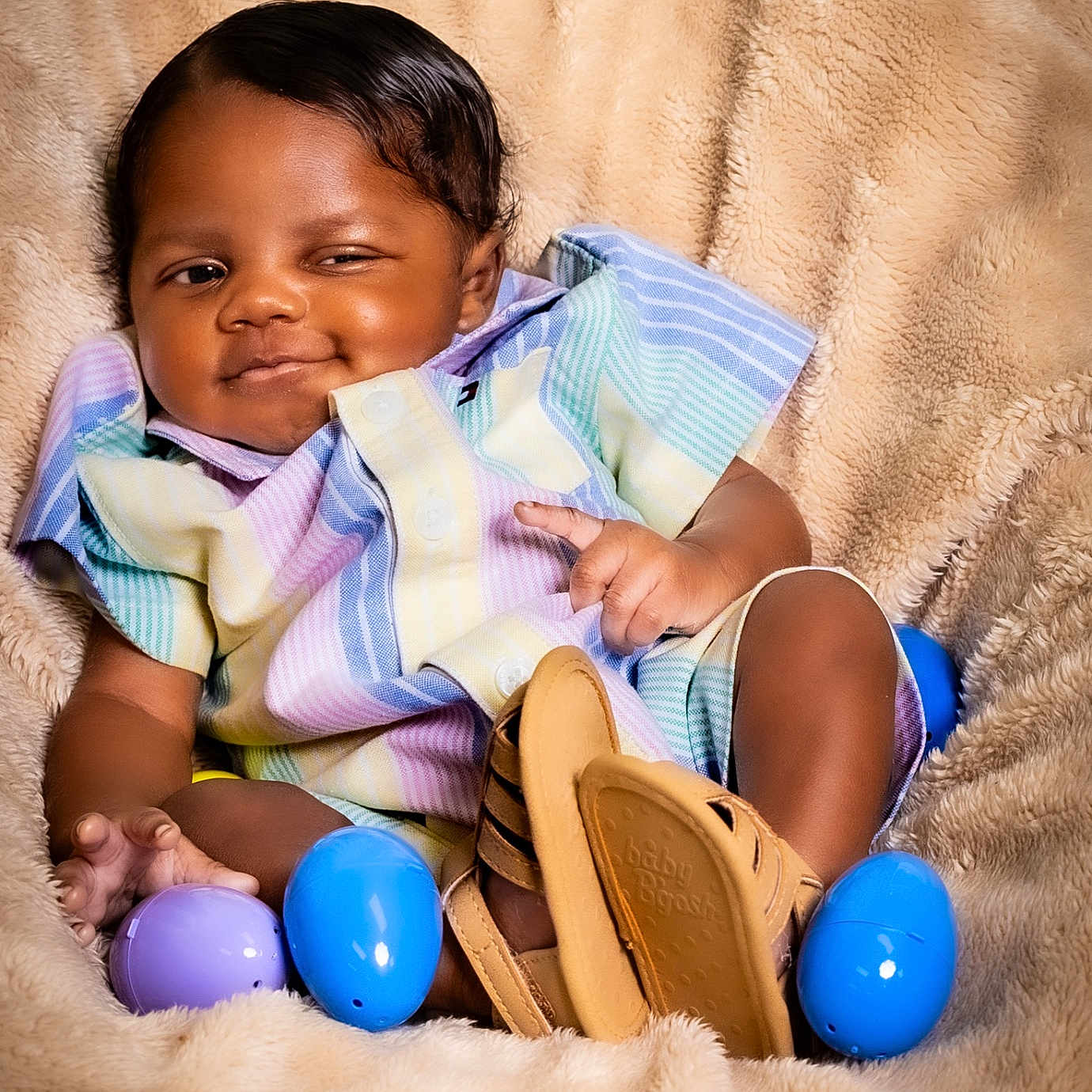 Jordan joined the competition — help win amazing prizes! baby, infant, smiling, striped_clothing, sandals, plastic_eggs, blanket, soft_texture, portrait, cute, child, relaxed, indoors, colorful, small_hands, happy, face, seated, cozy, playful