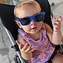 accessory, baby, blonde_hair, casual, child, cute, expression, face, fashion, hands, infant, outdoor, person, portrait, purple_dress, seat, small_person, stroller, summer, sunglasses