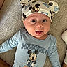 baby, blue_clothing, child, couch, cute, expression, fabric, face, happy, hat, headwear, indoor, infant, mickey_mouse, onesie, person, playful, smiling, tongue_out, young_child