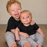 Apollo is registered to the contest to win money with this photo: child, baby, siblings, laughing, hugging, black_shirt, gray_pants, barefoot, indoor, wooden_floor, cute, happy, smiling, portrait, family, toddler, infant, people, two_children, candid