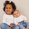 child, baby, smiling, curly_hair, white_shirt, blue_jeans, sitting, portrait, siblings, cute, happy, indoor, people, family, infant, toddler, casual_clothing, studio_light, closeup, friendship