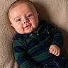 baby, child, smile, face, polo_shirt, striped_clothing, blue, green, jeans, hand, blanket, texture, portrait, cute, infant, relaxed, indoors, person, young_child, happy
