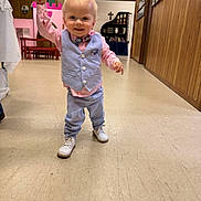 Marshall joined the competition — help win amazing prizes! toddler, child, boy, vest, bow_tie, shirt, pants, shoes, indoor, floor, hand_holding, adult_hand, wood_paneling, playhouse, bench, cabinet, bookshelf, cross, smiling, walking