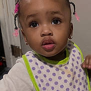 Jimmya is registered to the contest to win money with this photo: toddler, child, baby, indoor, polka_dot_bib, braided_hair, pink_beads, curious_expression, white_clothing, carpet, door, earrings, young_child, portrait, standing, face, person, home, cute, looking_up