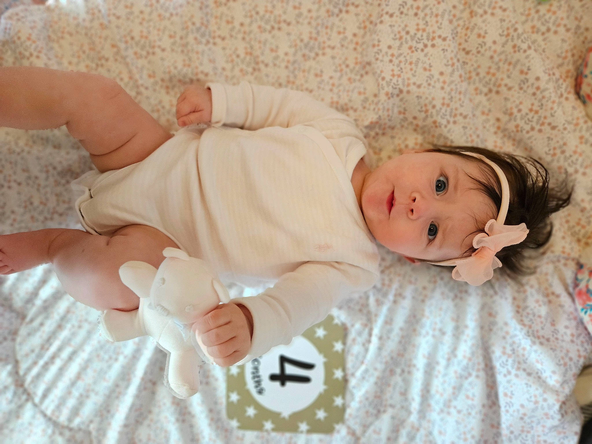 Eva is registered to the contest to win money with this photo: baby, baby_toddler_clothing, child, comfort, finger, foot, grass, happy, headgear, headwear, human_body, human_leg, linens, pattern, person, portrait_photography, skin, sleeve, textile, thigh