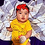 baby, child, infant, red_bow, yellow_shirt, mittens, blanket, winnie_the_pooh, cute, portrait, lying_down, soft_texture, indoor, close_up, young_child, headband, expression, clothing, person, smiling