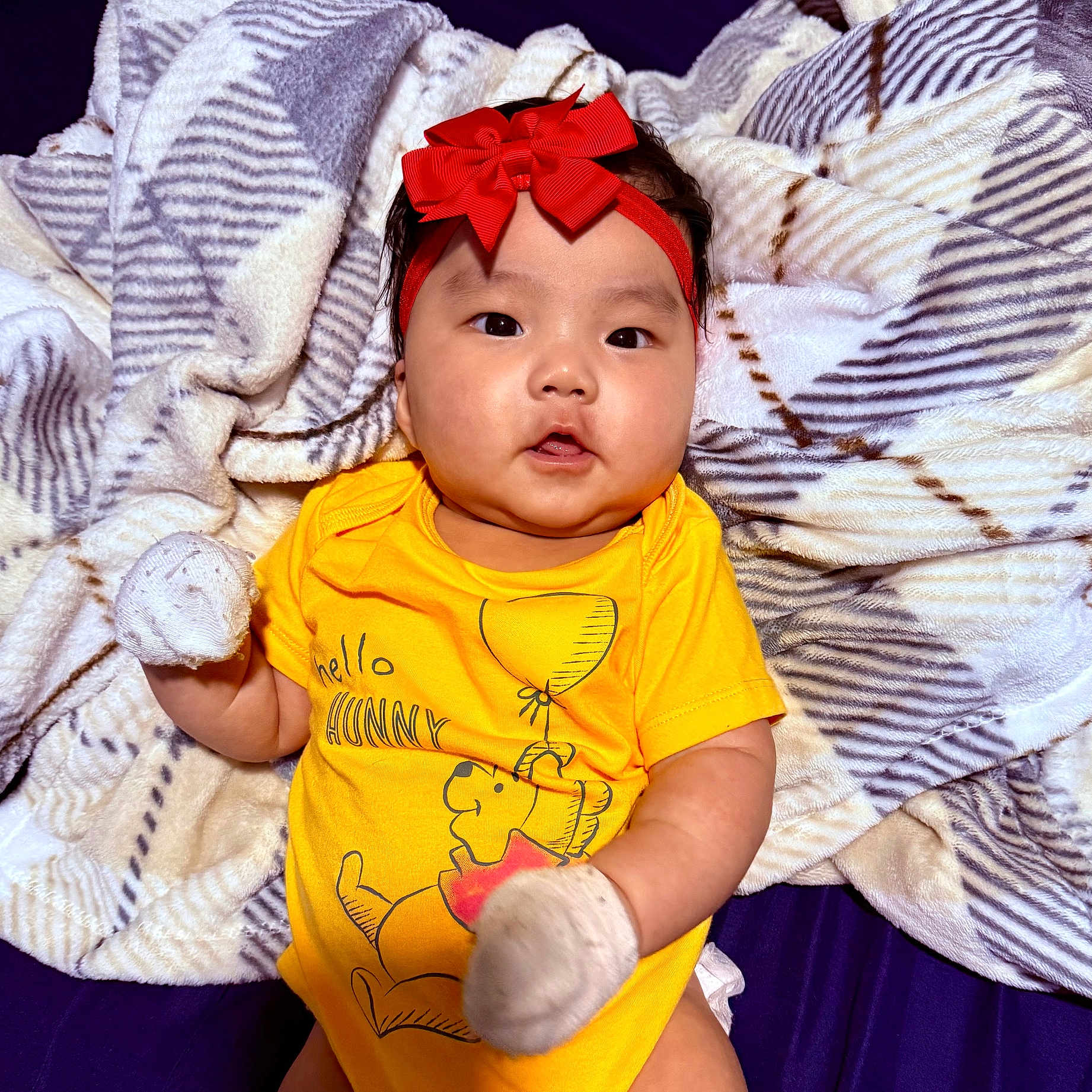 Xylah joined the competition — help win amazing prizes! baby, blanket, child, close_up, clothing, cute, expression, headband, indoor, infant, lying_down, mittens, person, portrait, red_bow, smiling, soft_texture, winnie_the_pooh, yellow_shirt, young_child