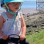 Agathe a rejoint le concours — aidez-le/la à gagner de superbes lots ! blue_sky, child, daylight, footwear, glasses, grass, helmet, horse, nature, outdoor, person, pony, rocks, saddle, sandals, shoreline, sky, summer, water, young_child