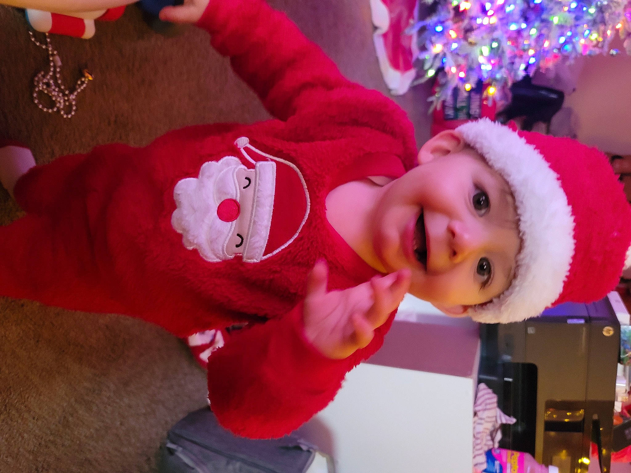 Chase is registered to the contest to win money with this photo: baby, baby_toddler_clothing, child, christmas, christmas_decoration, christmas_tree, event, fun, happy, hat, headgear, headwear, holiday, joy, magenta, person, pink, plant, purple, red