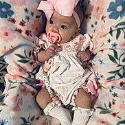 Lyla joined the competition — help win amazing prizes! baby, infant, pacifier, bow, blanket, floral_pattern, pink, white_socks, cute, clothing, portrait, child, indoors, soft_texture, cozy, lying_down, newborn, hand, face, wide_eyes