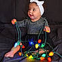 Braylee is registered to the contest to win money with this photo: baby, child, girl, headband, white_bow, dress, sparkly_dress, christmas_lights, colorful_lights, sitting, dark_background, happy, smiling, indoors, portrait, cute, holiday, festive, playing, toddler