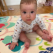 Gabriel participe au concours pour gagner de l'argent avec cette photo : baby, child, infant, play_mat, floor, wooden_floor, dog, pet, indoor, cute, curious, pajamas, long_sleeve, colorful, patterned, hand, foot, face, expression, room