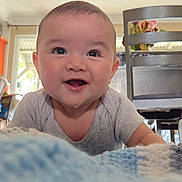 Odin is registered to the contest to win money with this photo: baby, infant, smile, happy, face, eyes, onesie, blanket, crawling, portrait, closeup, cheeks, home_interior, chair, table, wooden_chair, tongue, cute, expression, portrait_photography