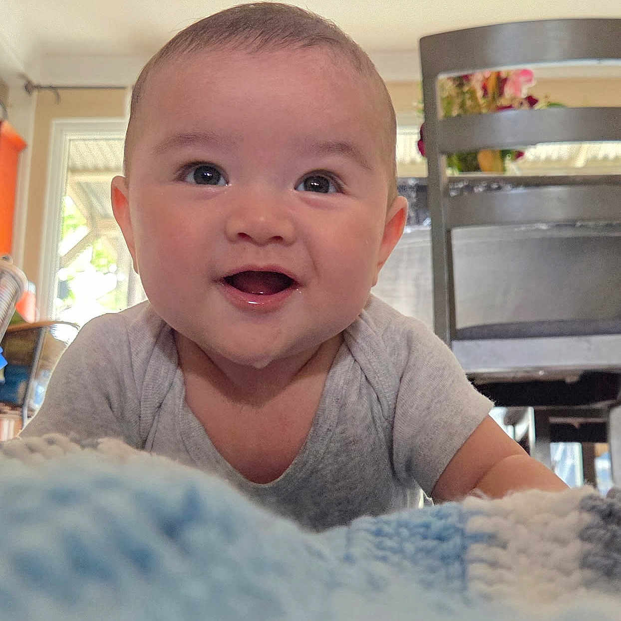 Odin is registered to the contest to win money with this photo: baby, blanket, chair, cheeks, closeup, crawling, cute, expression, eyes, face, happy, home_interior, infant, onesie, portrait, portrait_photography, smile, table, tongue, wooden_chair