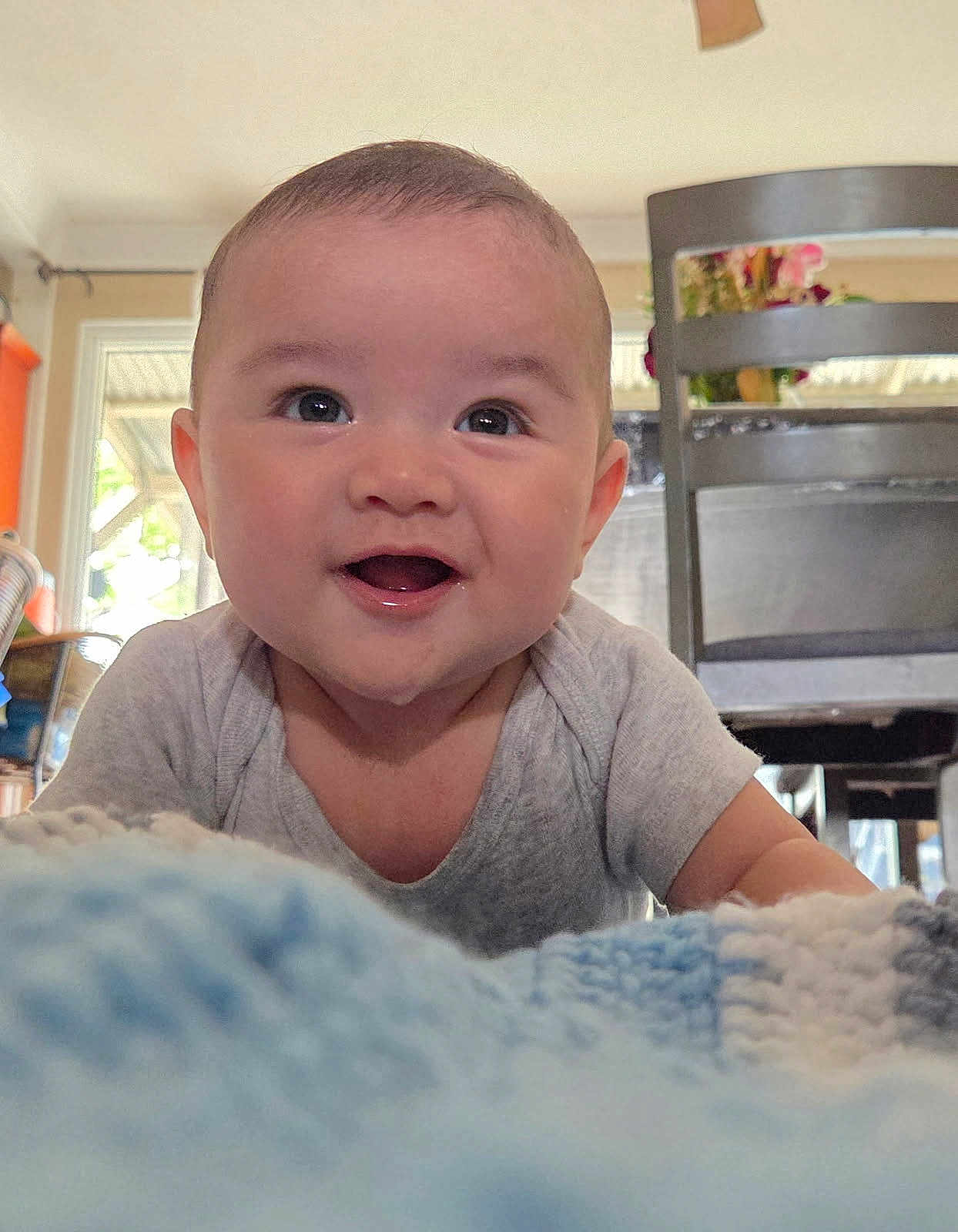 Odin is registered to the contest to win money with this photo: baby, infant, smile, happy, face, eyes, onesie, blanket, crawling, portrait, closeup, cheeks, home_interior, chair, table, wooden_chair, tongue, cute, expression, portrait_photography