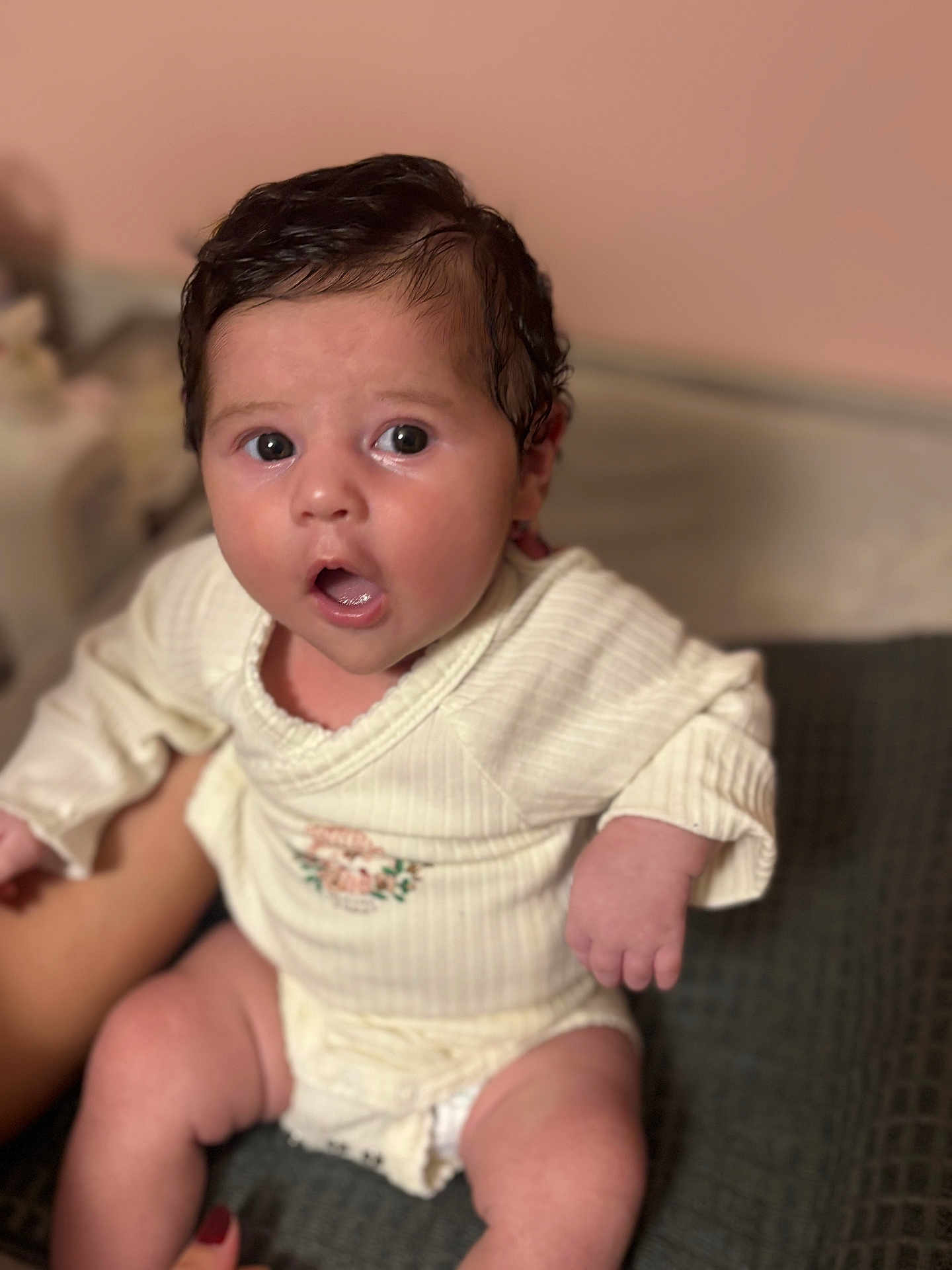 Selena a rejoint le concours — aidez-le/la à gagner de superbes lots ! baby, infant, child, surprised, face, skin, hair, clothing, onesie, hand, legs, person, indoors, soft_light, blurred_background, expression, cute, young, portrait, sitting