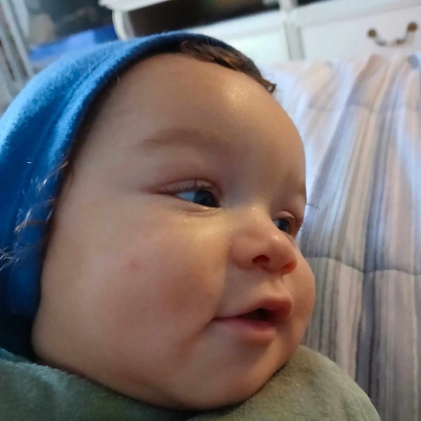 Nigel joined the competition — help win amazing prizes! baby, bed, blanket, blue_hat, cheeks, child, closeup, cozy, curious, face, furniture, headwear, indoor, infant, portrait, profile, skin, sleeping_area, soft_light, young_child