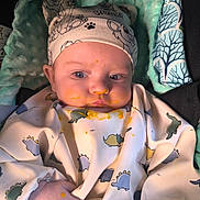 Eden participe au concours pour gagner de l'argent avec cette photo : baby, infant, face, eyes, hat, bib, baby_food, stain, messy, blanket, car_seat, dinosaur_pattern, hand, cheeks, skin, cute, feeding_time, hood, clothing, portrait