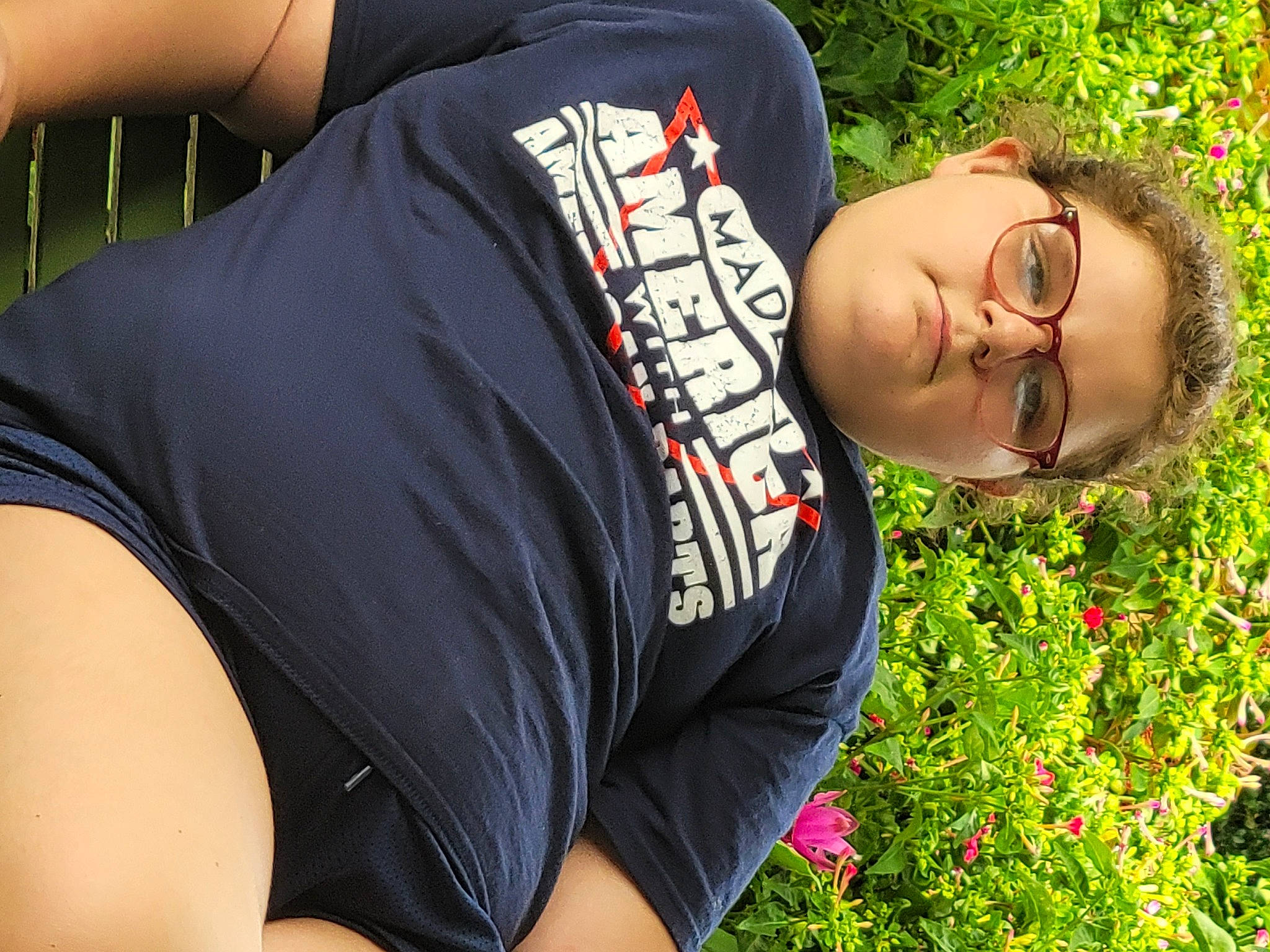 Emma is registered to the contest to win money with this photo: abdomen, chest, elbow, eyewear, fun, garden, grass, happy, human_leg, jewellery, leisure, muscle, pattern, people_in_nature, person, plant, sleeve, sportswear, t_shirt, thigh